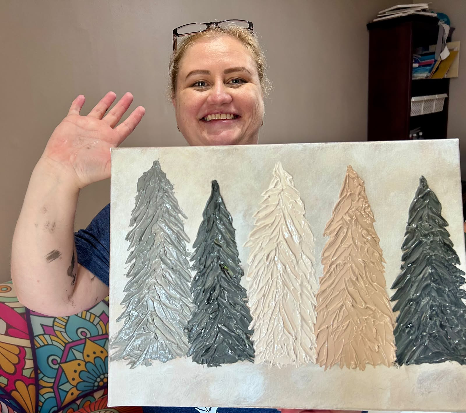 Student smiling with her textured pine tree painting