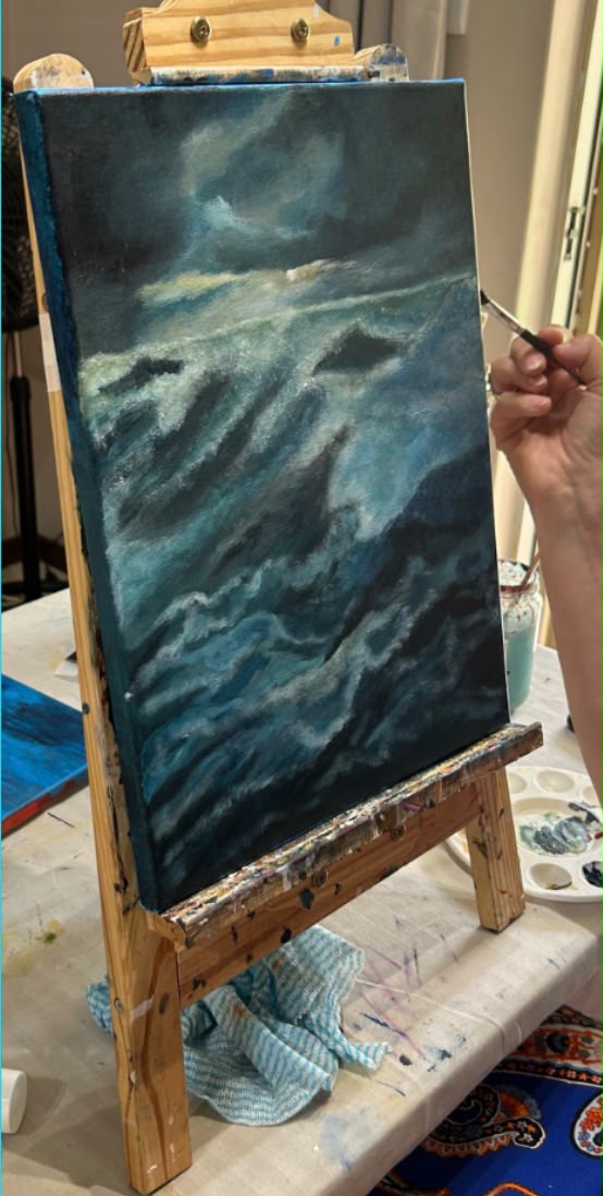 Moody stormy seascape painting in progress on an easel